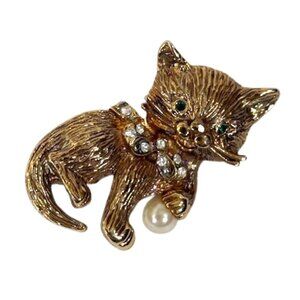 Gold-tone cat holding a pearly ball brooch/pin.